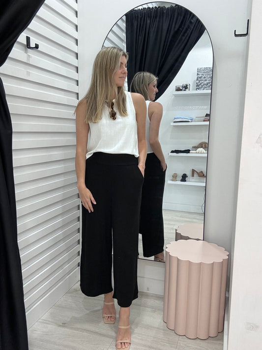 The Mari Pants in Black made from a Linen blend fabric for comfort and coolness. Worn with the Mari Top in White