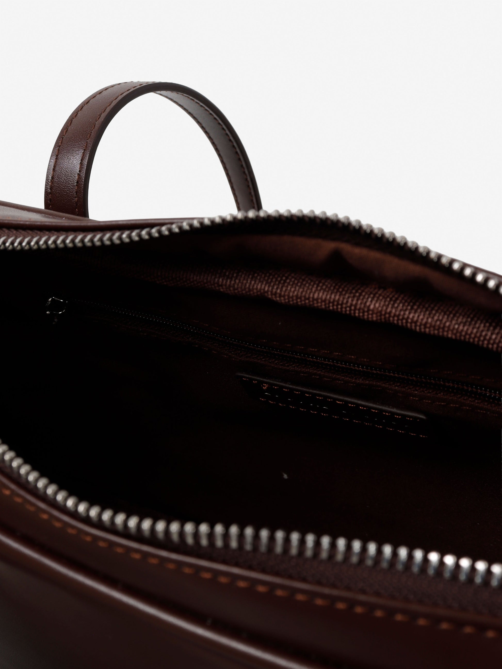 Close-up of a brown leather bag with a zipper on a white background