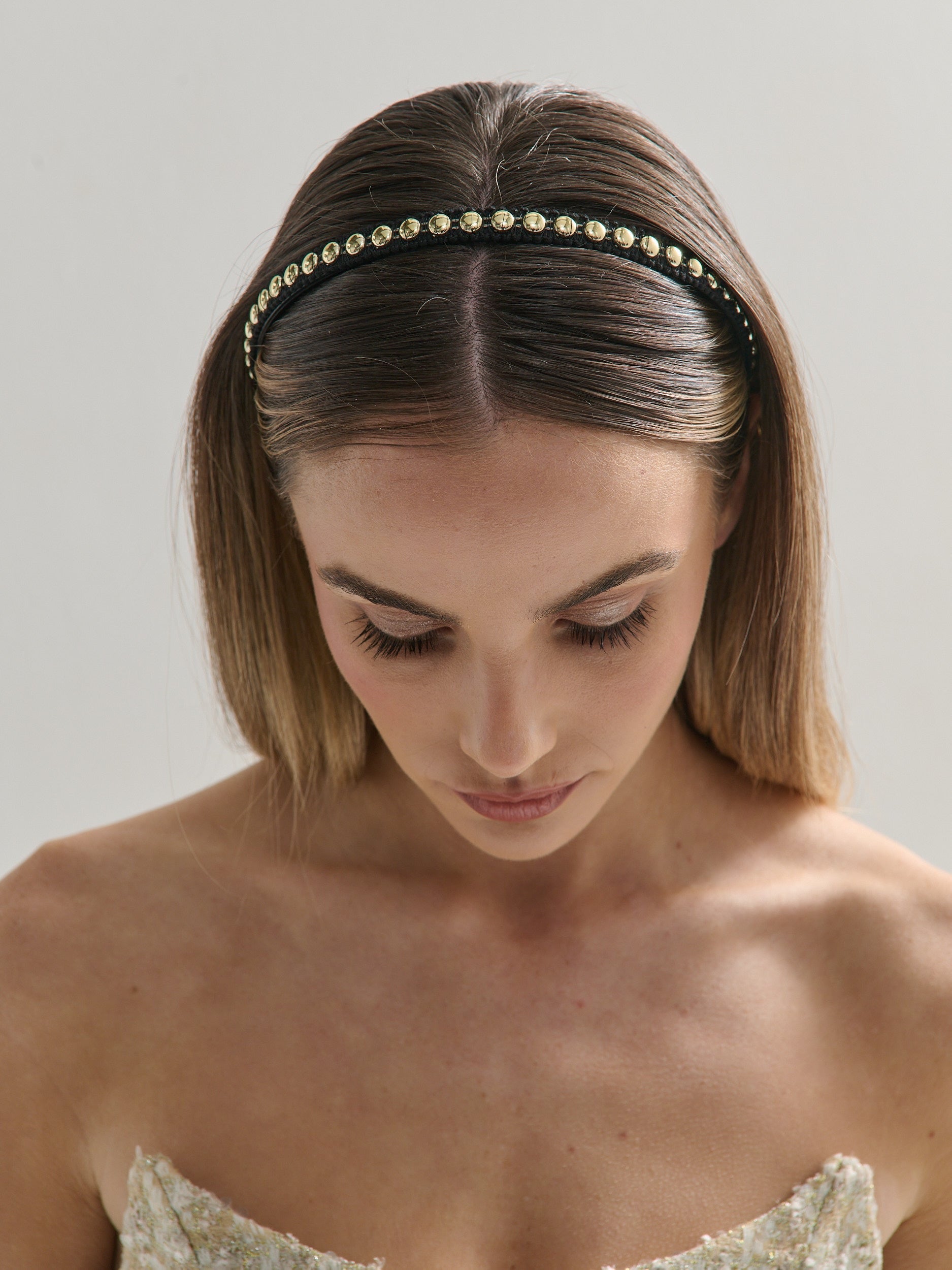 Woman wearing a decorative headband with a plain background