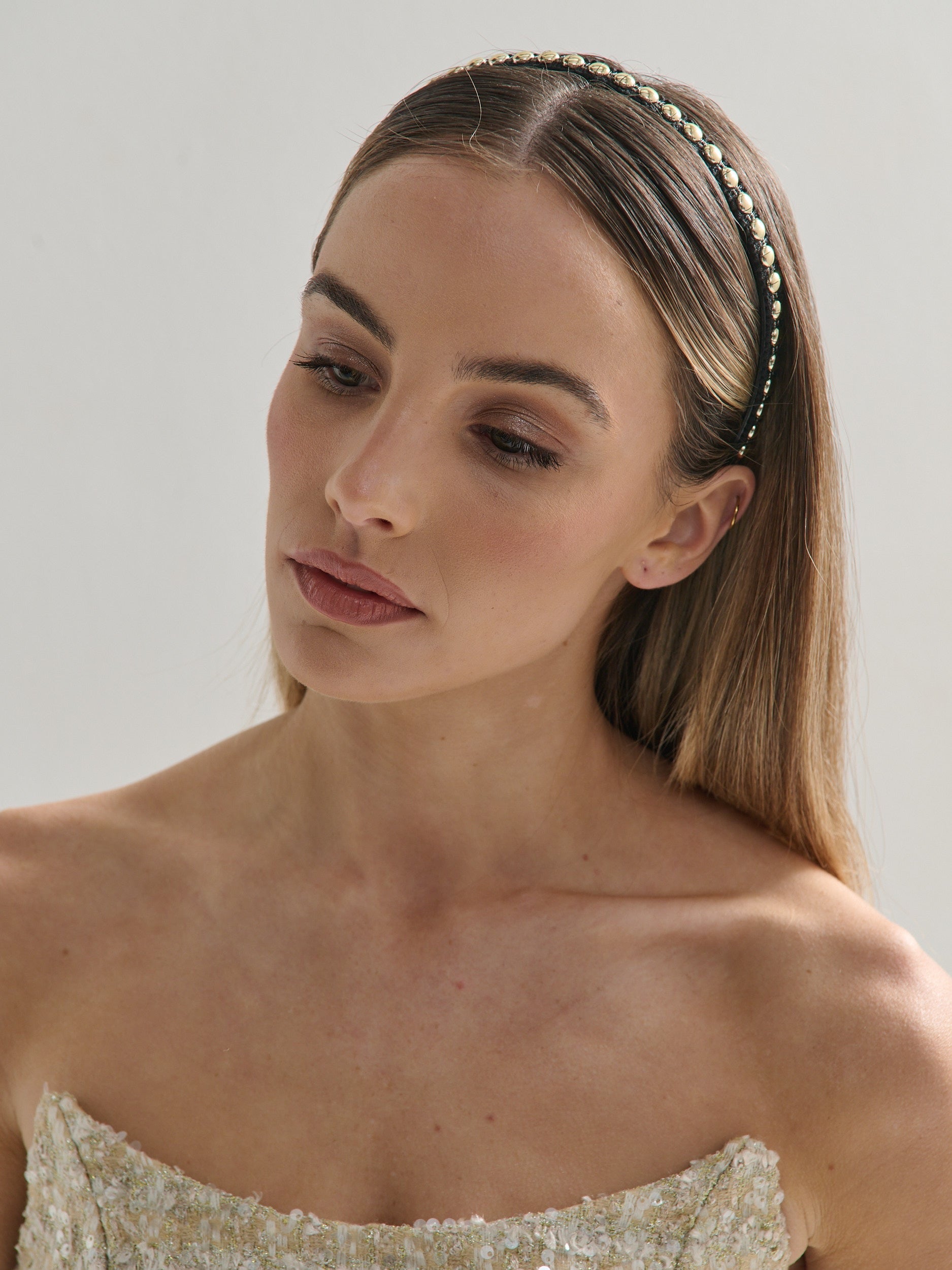 Woman wearing a decorative headband with a plain background