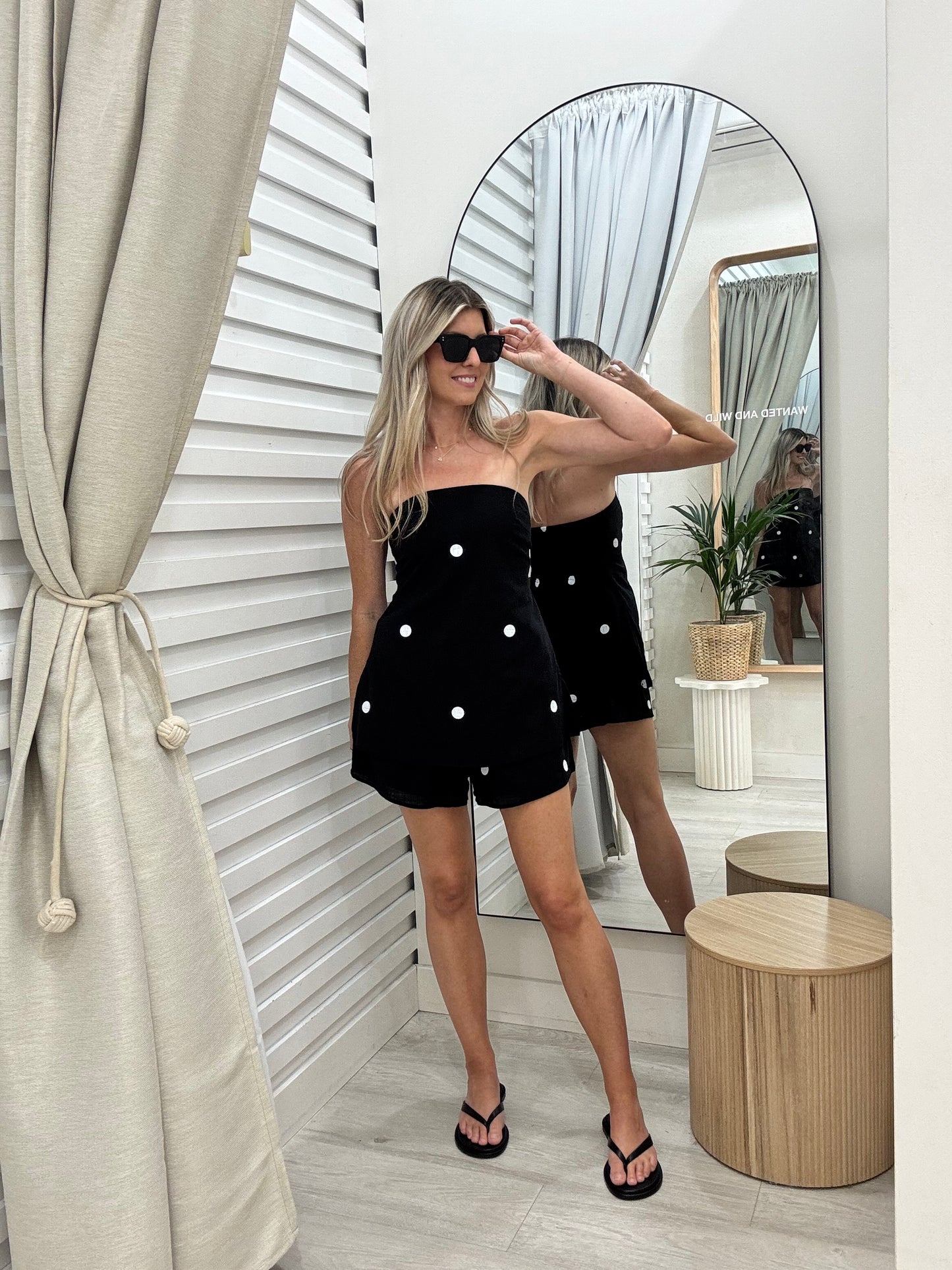 Woman wearing sunglasses and wearing Black and White Spot Strapless Top with matching Shorts By Frankie at Wanted and Wild