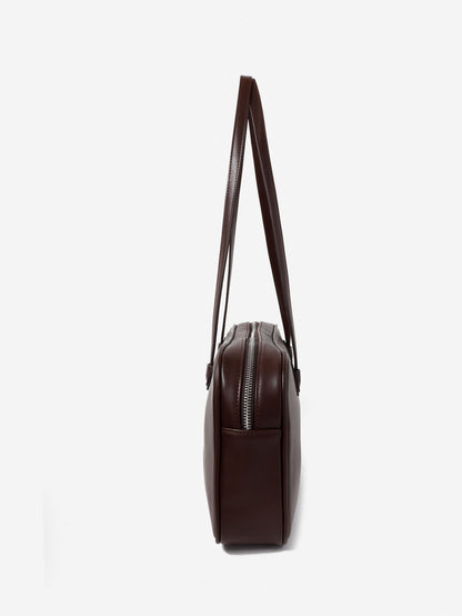 Brown leather handbag with a strap on a white background